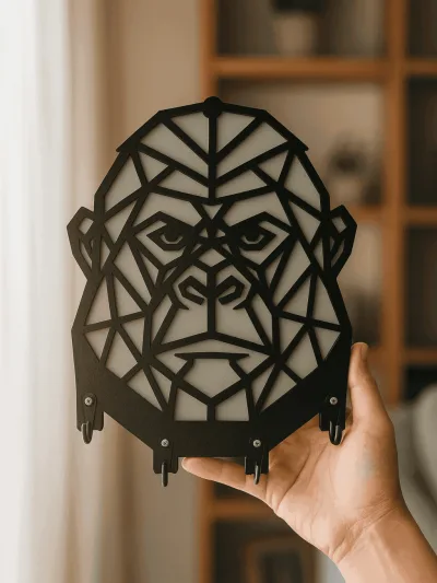 Elde tutulan siyah beyaz geometrik goril figürlü MDF anahtarlık askısı, katmanlı tasarım ve metal kanca detayı
