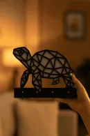 Elde tutulan modern kaplumbağa siluetli siyah MDF duvar askılığı, dört kancalı anahtar ve aksesuar asma aparatı