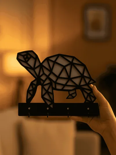 Elde tutulan modern kaplumbağa siluetli siyah MDF duvar askılığı, dört kancalı anahtar ve aksesuar asma aparatı