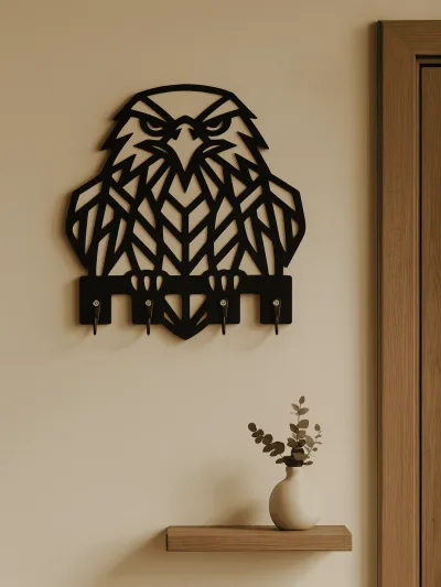 Kapı yanında duvara asılmış siyah geometrik kartal figürlü ahşap anahtarlık askısı, modern dekoratif çoklu kancalı anahtar düzenleyici